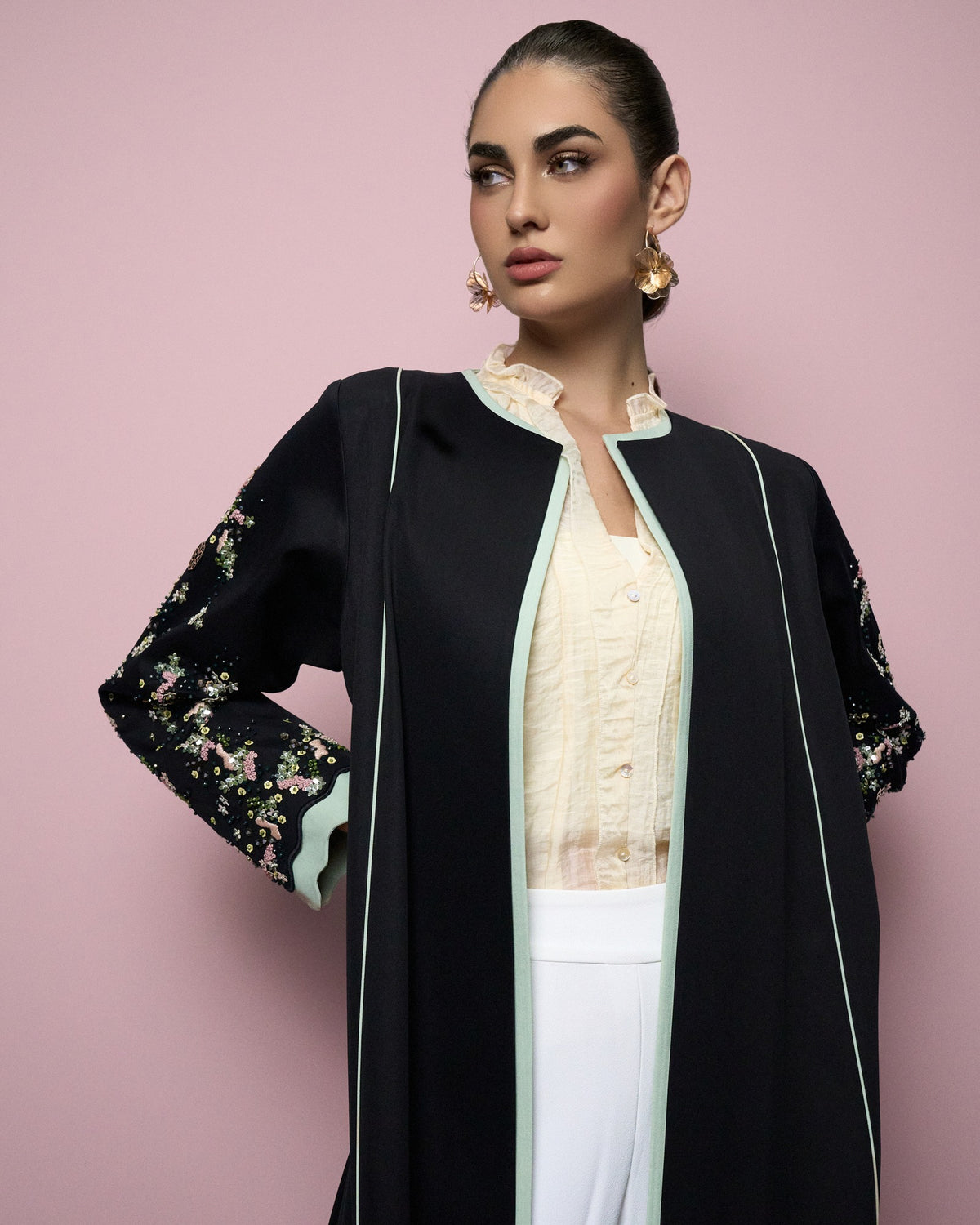 Model in the MS6-F163 black crepe abaya with floral embroidered sleeves and mint piping - MIRA Y MANO