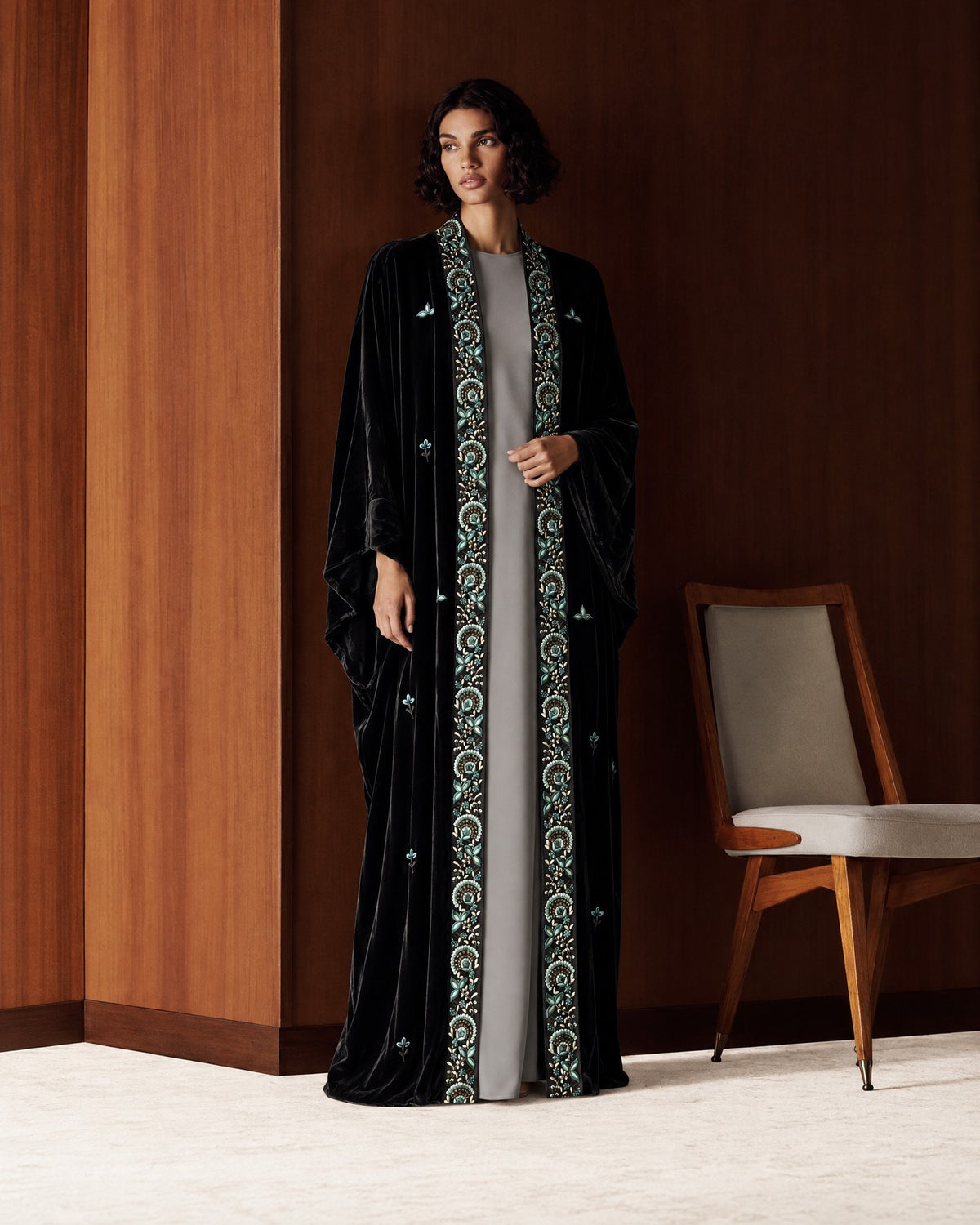 Two autumn looks in wood-panelled rooms: a black velvet abaya with a teal and cream embroidered border over a grey dress, and a goldenrod washed-silk abaya over a dark brown dress