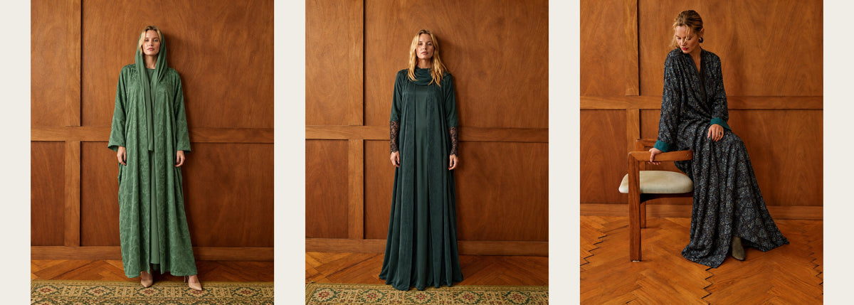 Three autumn looks in a wood-panelled room: a green jacquard hooded abaya, a dark green washed-silk abaya with lace cuffs, and a teal jacquard abaya