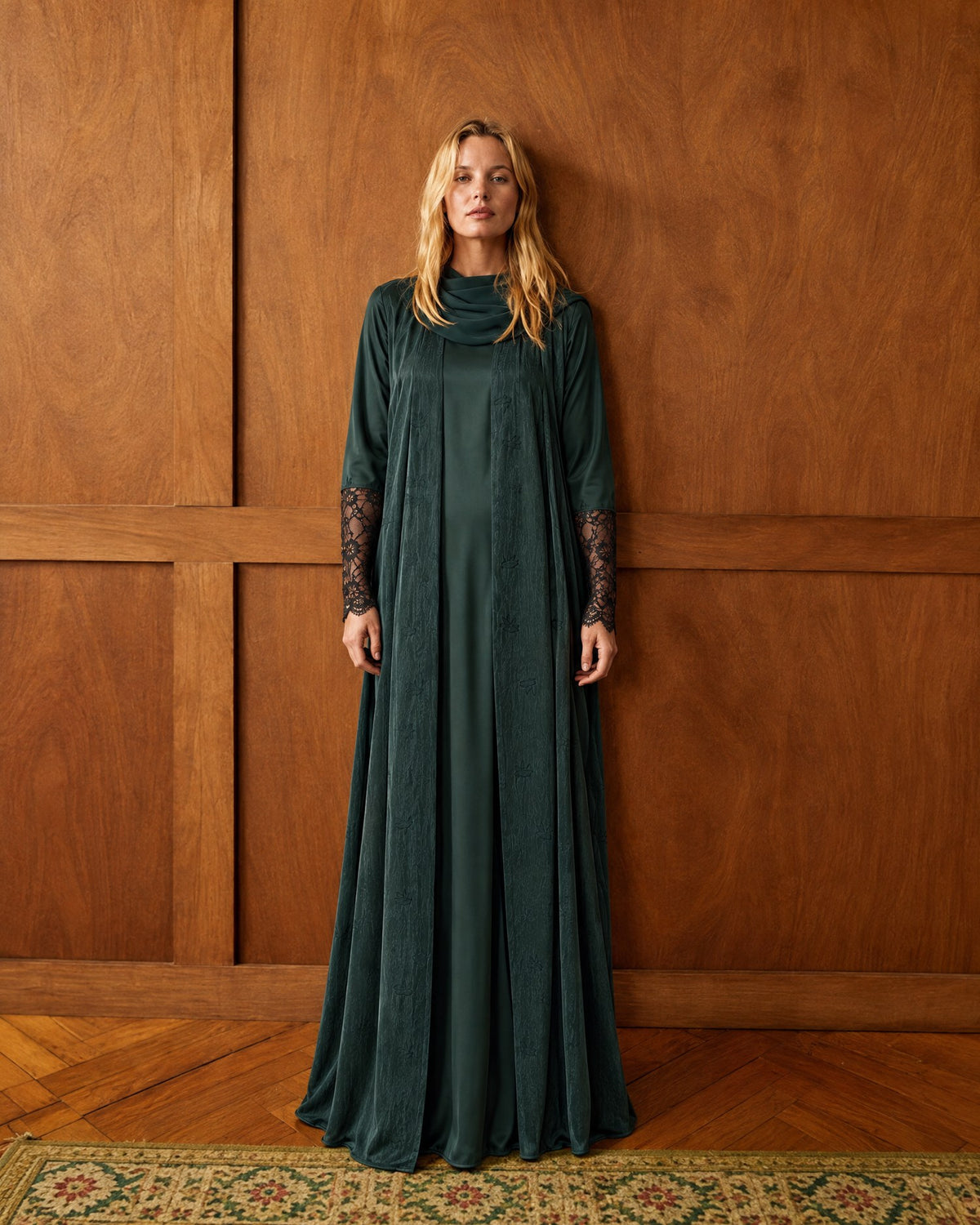 Three autumn looks in a wood-panelled room: a green jacquard hooded abaya, a dark green washed-silk abaya with lace cuffs, and a teal jacquard abaya