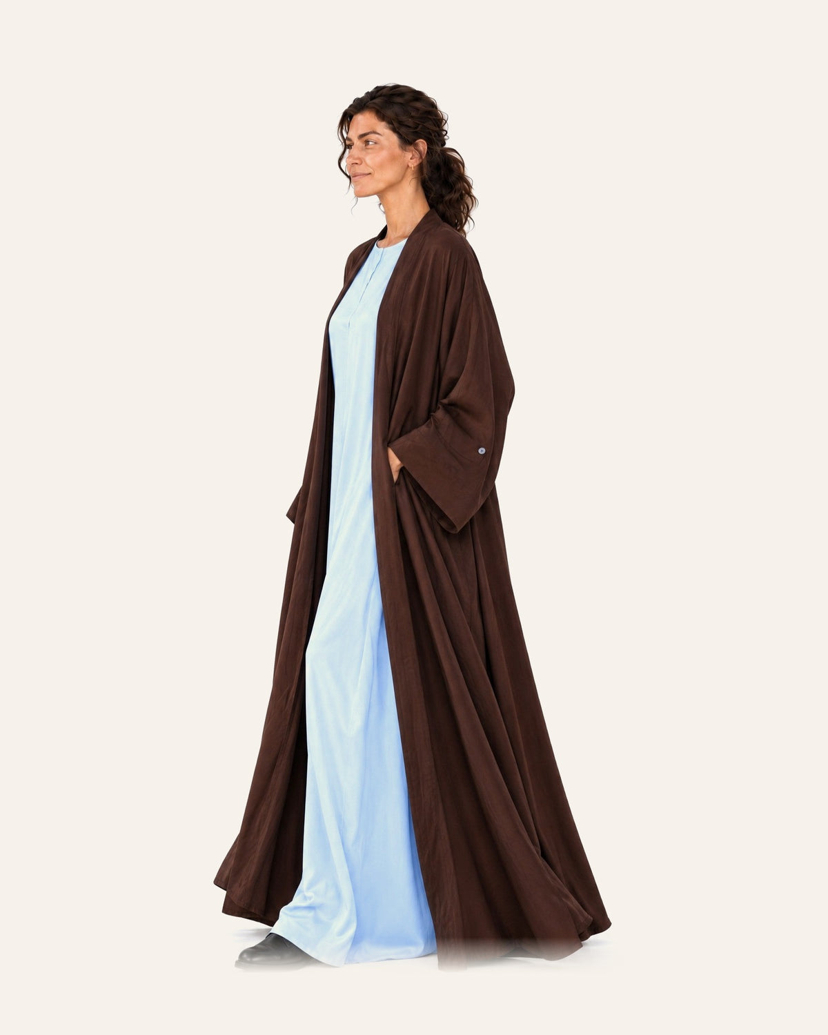 Maison Maj Japanese silk brown abaya set worn open over a pale blue dress, on a plain cream studio background