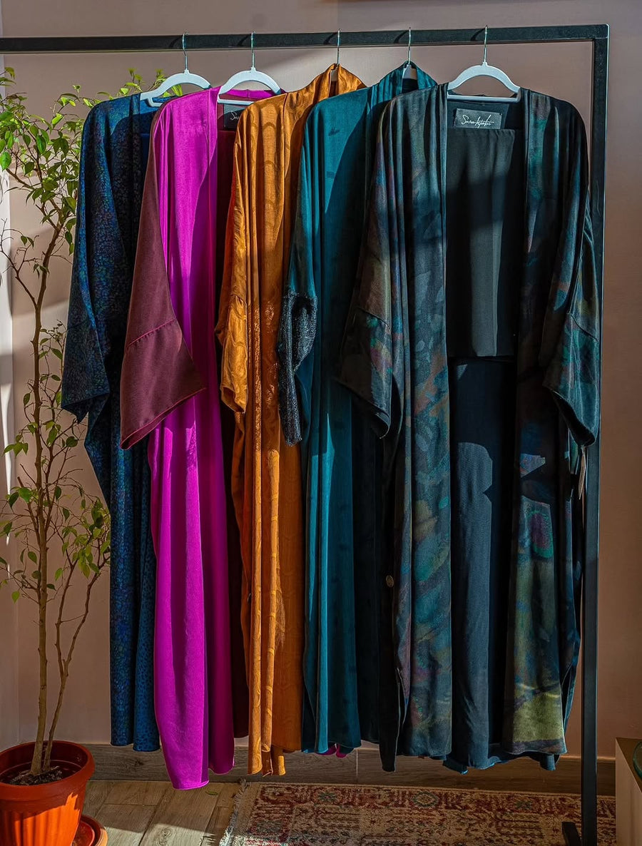 Silk abayas in navy, magenta, amber and teal on a rail